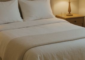 Wichtige Themen - Schlafhygiene-min Schön gemachtes Bett mit heller Bettwäsche in ruhiger, gemütlicher Atmosphäre – Sinnbild für guten Schlaf und erholsame Nächte.